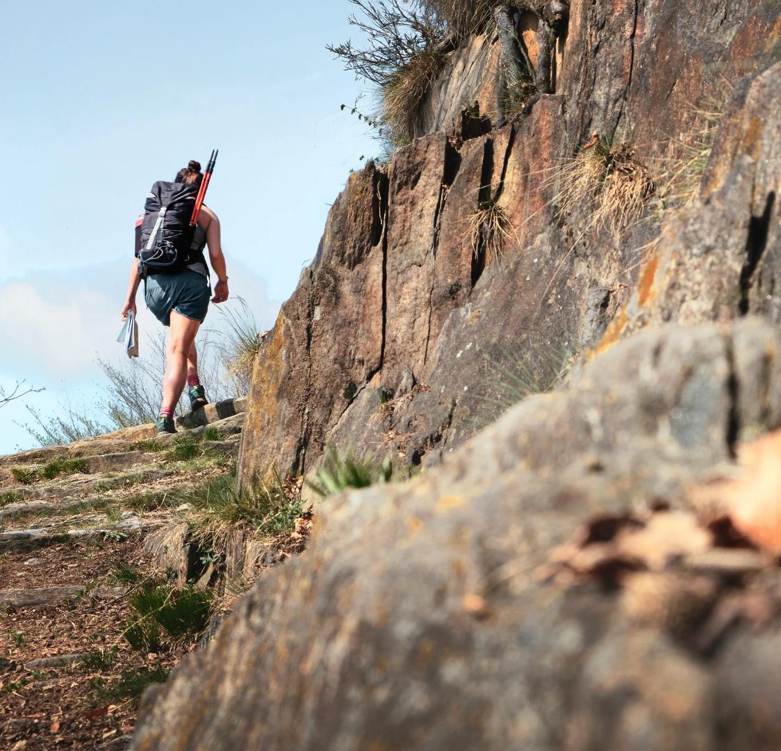 Personne en randonnée sur un sentier rocheux en Corse-du-Sud